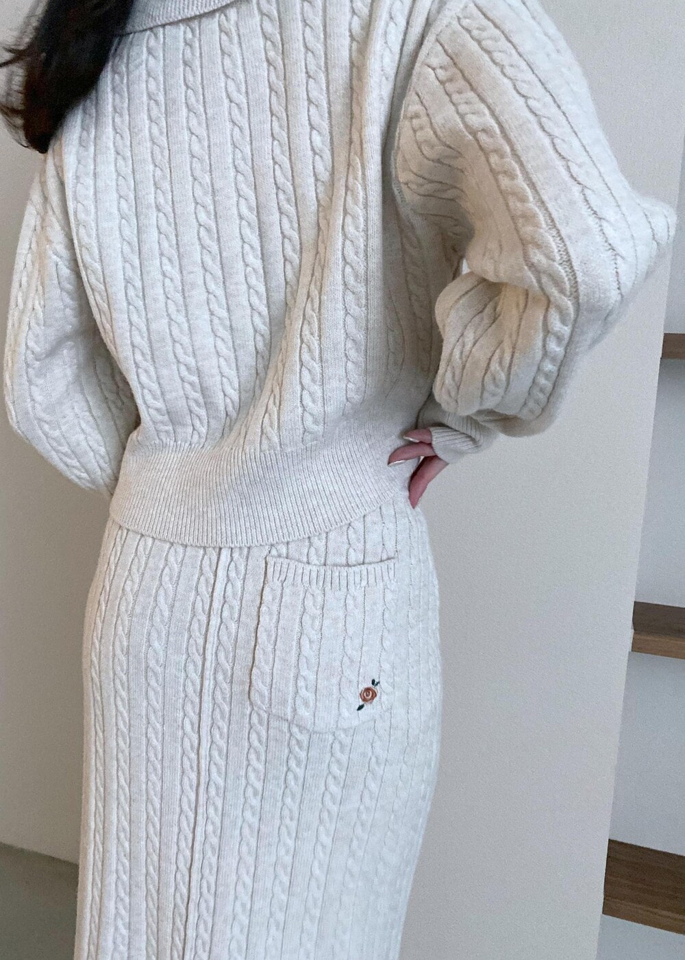 グリーン系のショルダーバッグ、ベージュ系のブーツ、ベージュ系のスカートを着用したレディースの冬コーディネートの4枚目の写真