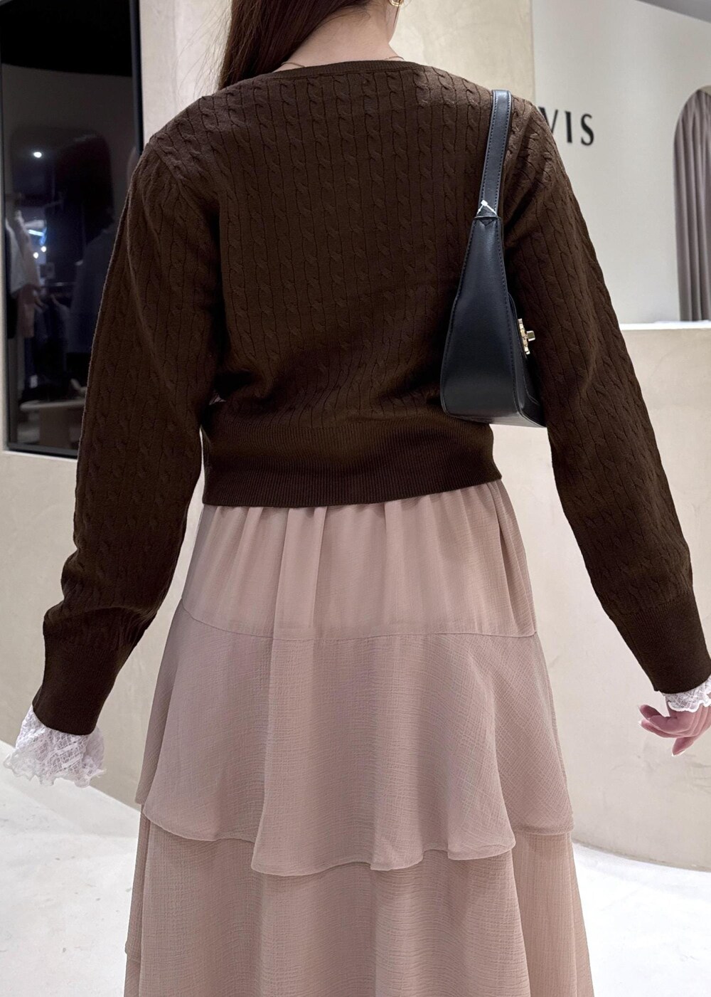 ブラック系のパンプス、ピンク系のスカート、ブラウン系のカーディガン/ボレロを着用したレディースの秋コーディネートの6枚目の写真