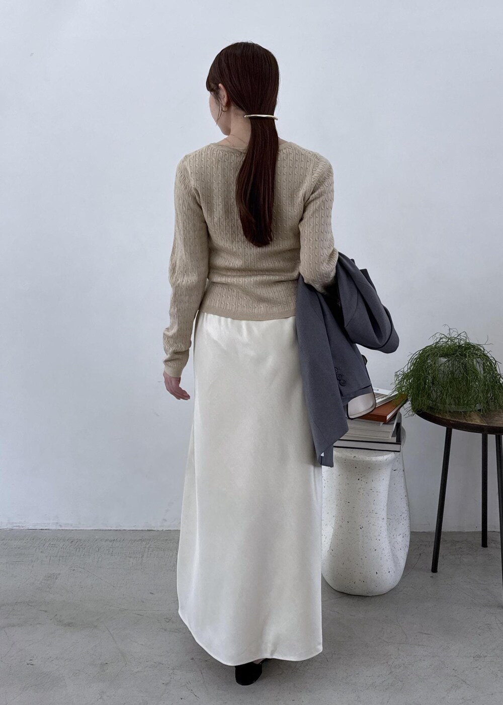 グレー系のテーラードジャケット、ブラック系のブーツ、ホワイト系のスカートを着用したレディースの秋コーディネートの9枚目の写真