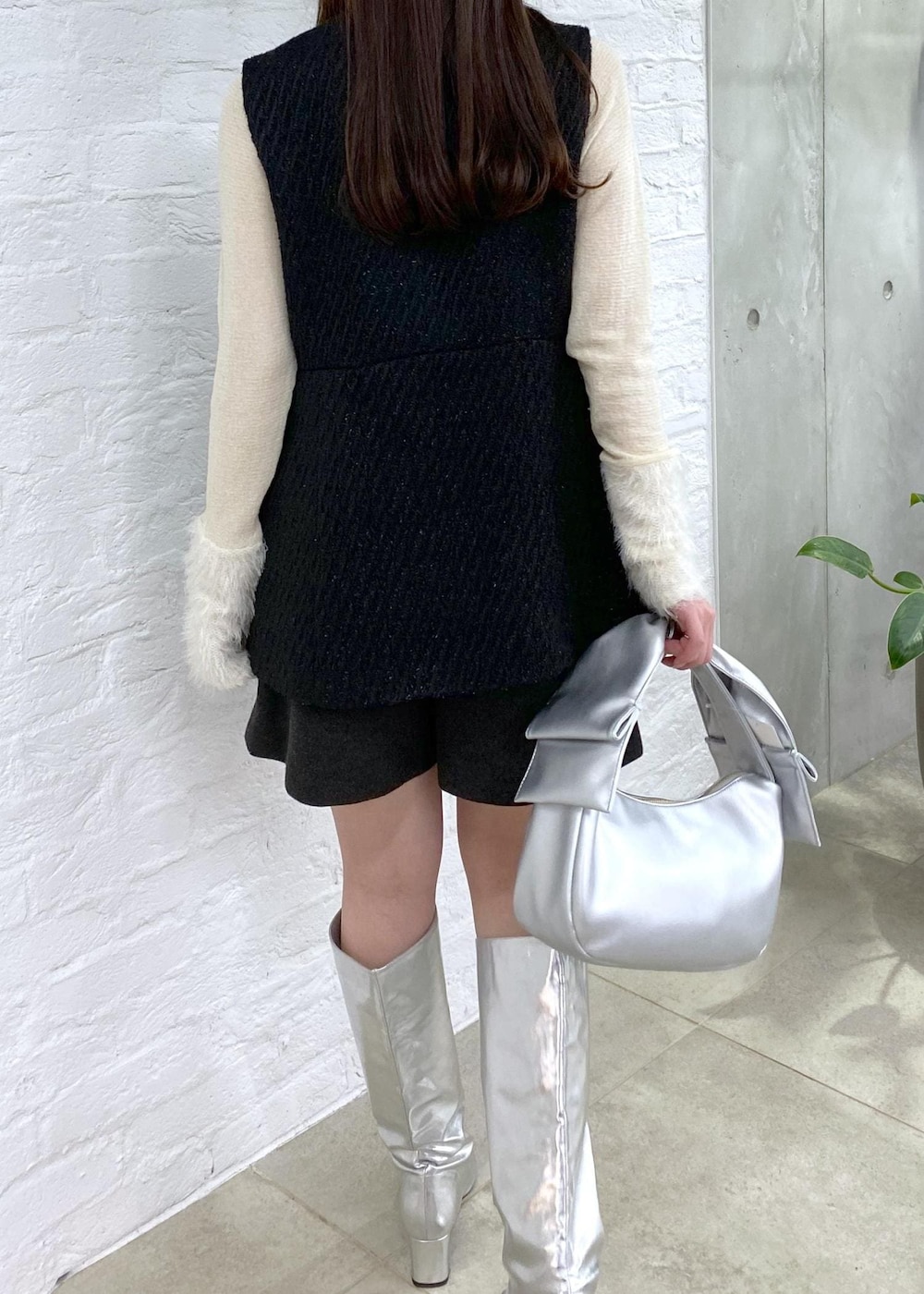 グレー系のその他パンツ、シルバー系のブーツ、ホワイト系のニット/セーターを着用したレディースの冬コーディネートの7枚目の写真