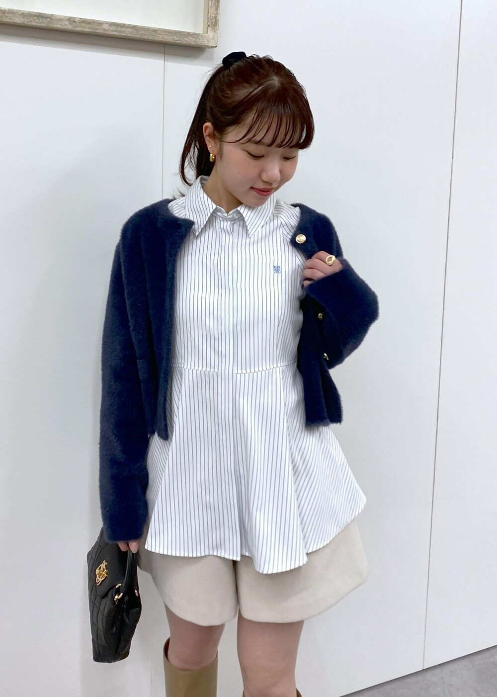 ベージュ系のブーツ、ブルー系のカーディガン/ボレロ、ベージュ系のその他パンツを着用したレディースの冬コーディネートの2枚目の写真