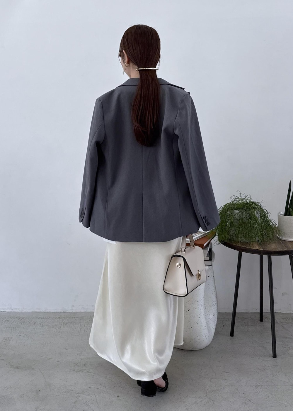 グレー系のテーラードジャケット、ブラック系のブーツ、ホワイト系のスカートを着用したレディースの秋コーディネートの10枚目の写真