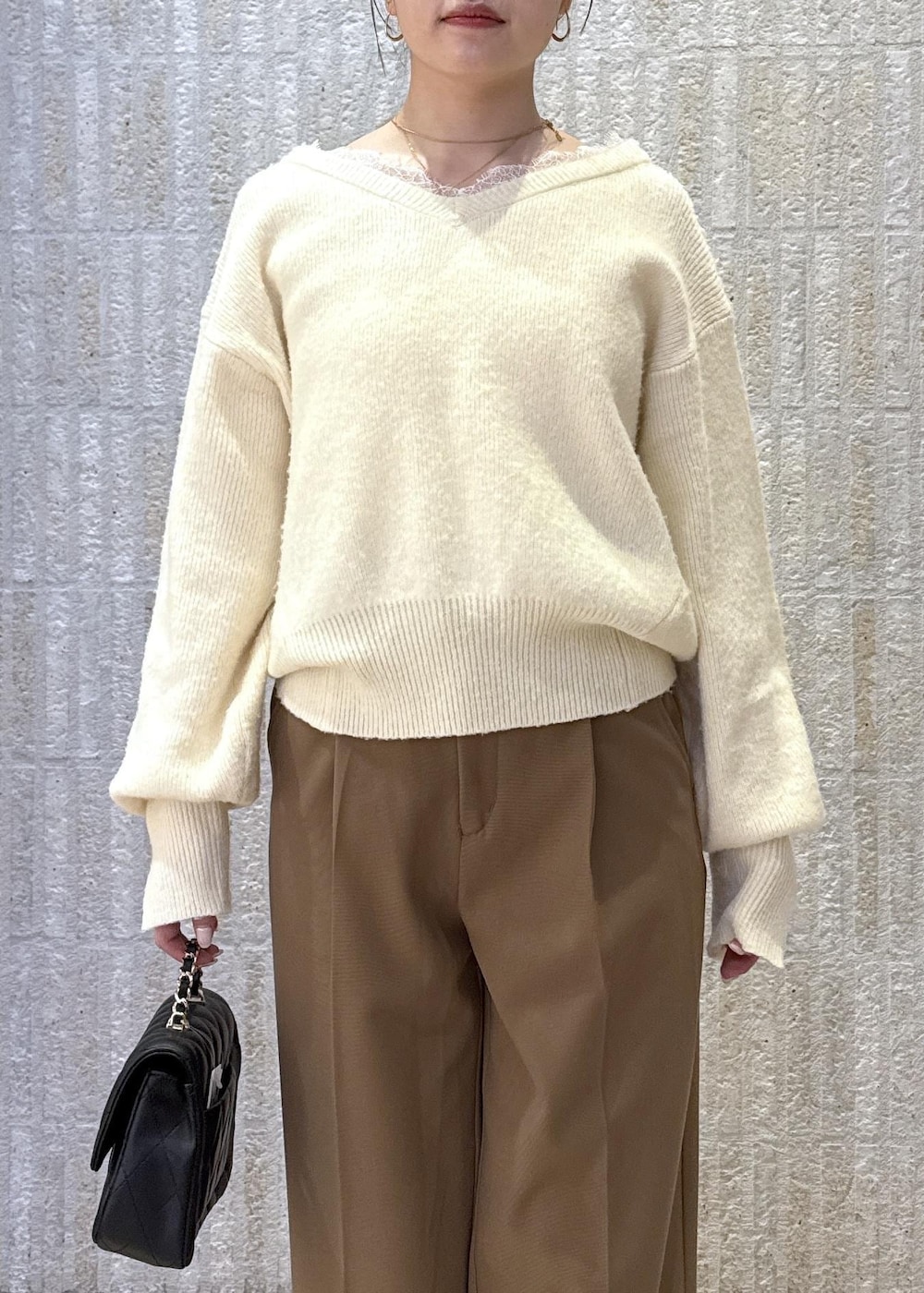 グレー系のブルゾン、ホワイト系のニット/セーター、イエロー系のその他パンツを着用したレディースの冬コーディネートの3枚目の写真