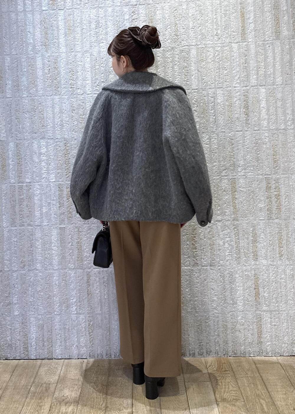 グレー系のブルゾン、ホワイト系のニット/セーター、イエロー系のその他パンツを着用したレディースの冬コーディネートの9枚目の写真