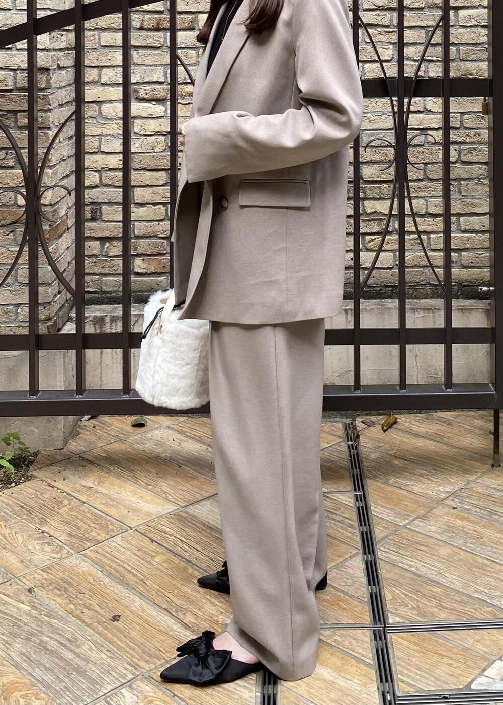 ブラック系のサンダル、ホワイト系のショルダーバッグ、ブラック系のニット/セーターを着用したレディースの秋コーディネートの5枚目の写真