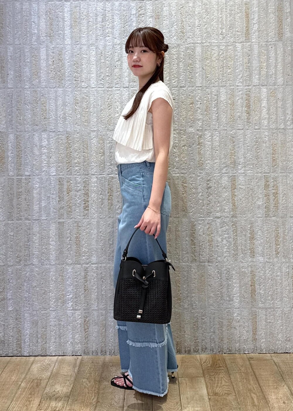 ブラック系のショルダーバッグ、ブラック系のサンダル、ホワイト系のキャミソールを着用したレディースの夏コーディネートの5枚目の写真