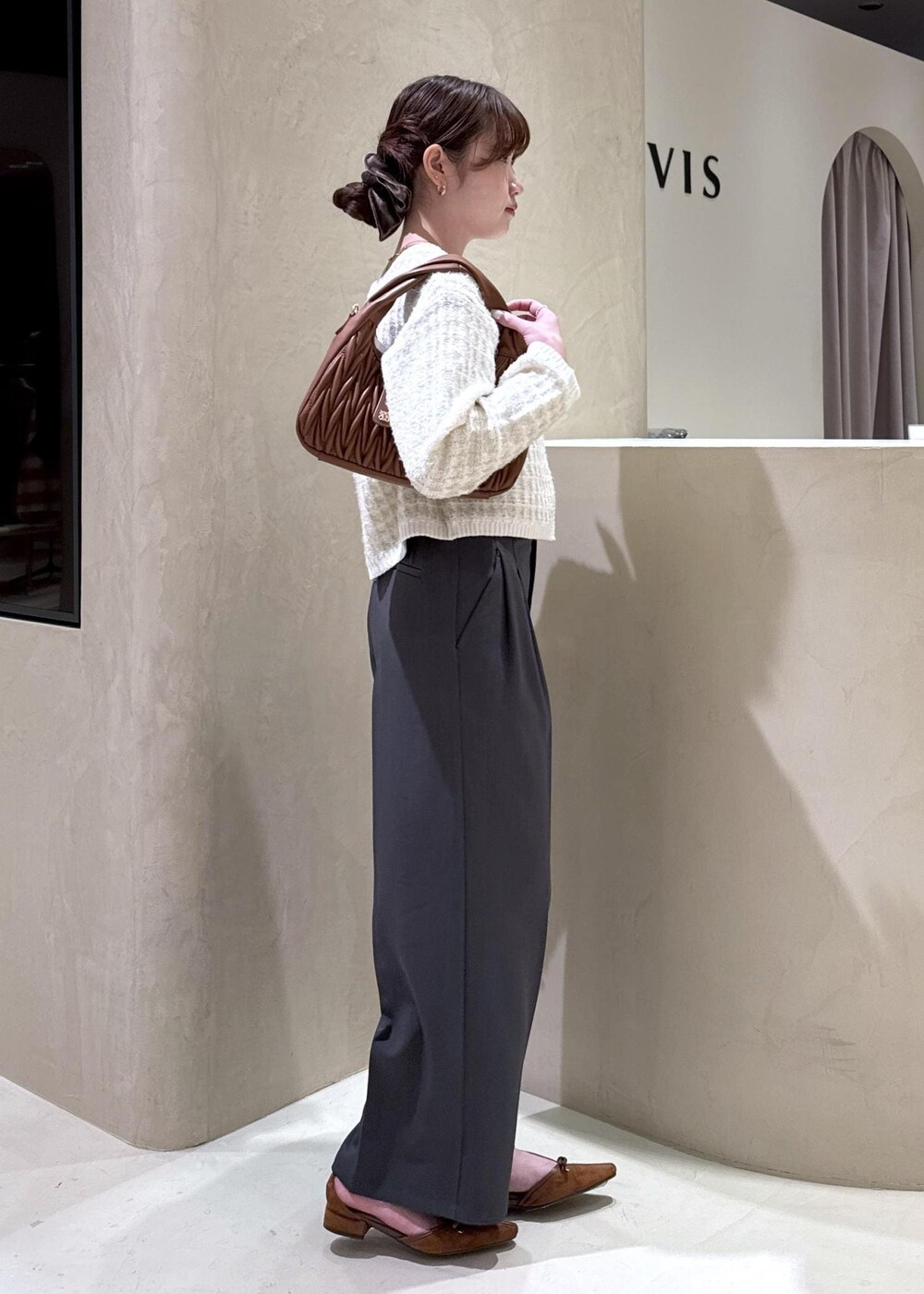 イエロー系のパンプス、ブラウン系のハンドバッグ、ホワイト系のカーディガン/ボレロを着用したレディースの秋コーディネートの5枚目の写真