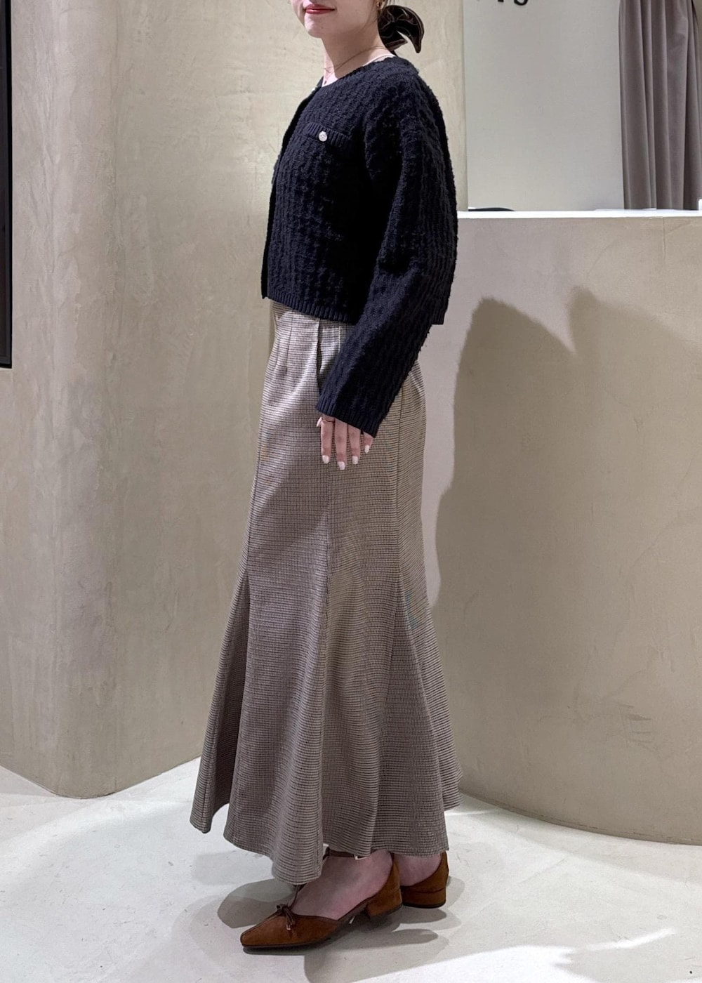 ブラウン系のショルダーバッグ、イエロー系のパンプス、ベージュ系のスカートを着用したレディースの秋コーディネートの5枚目の写真