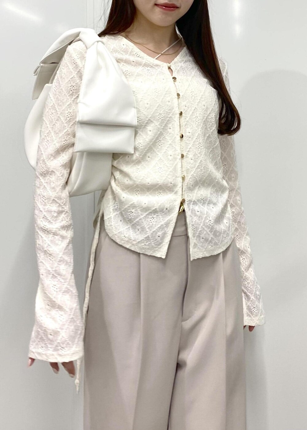 ブラウン系のパンプス、ホワイト系のキャミソール、ホワイト系のカーディガン/ボレロを着用したレディースの冬コーディネートの3枚目の写真