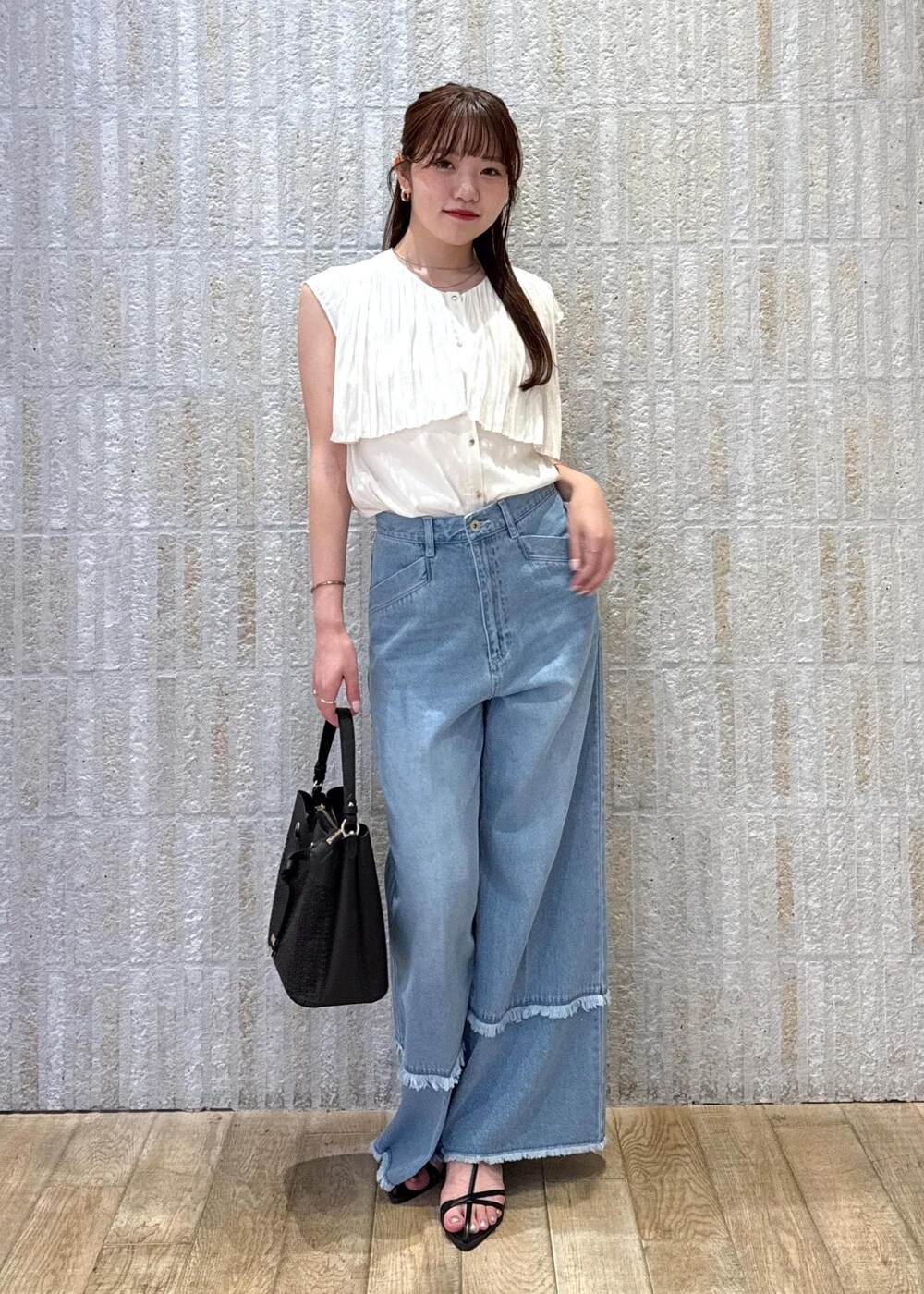 ブラック系のショルダーバッグ、ブラック系のサンダル、ホワイト系のキャミソールを着用したレディースの夏コーディネートの2枚目の写真