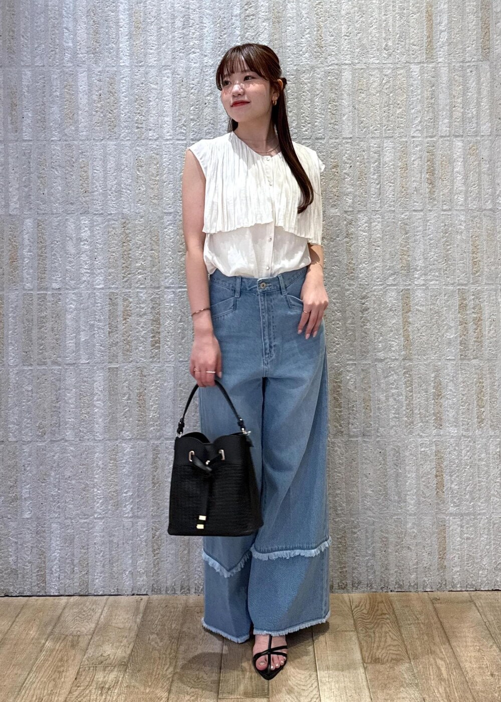 ブラック系のショルダーバッグ、ブラック系のサンダル、ホワイト系のキャミソールを着用したレディースの夏コーディネートの3枚目の写真