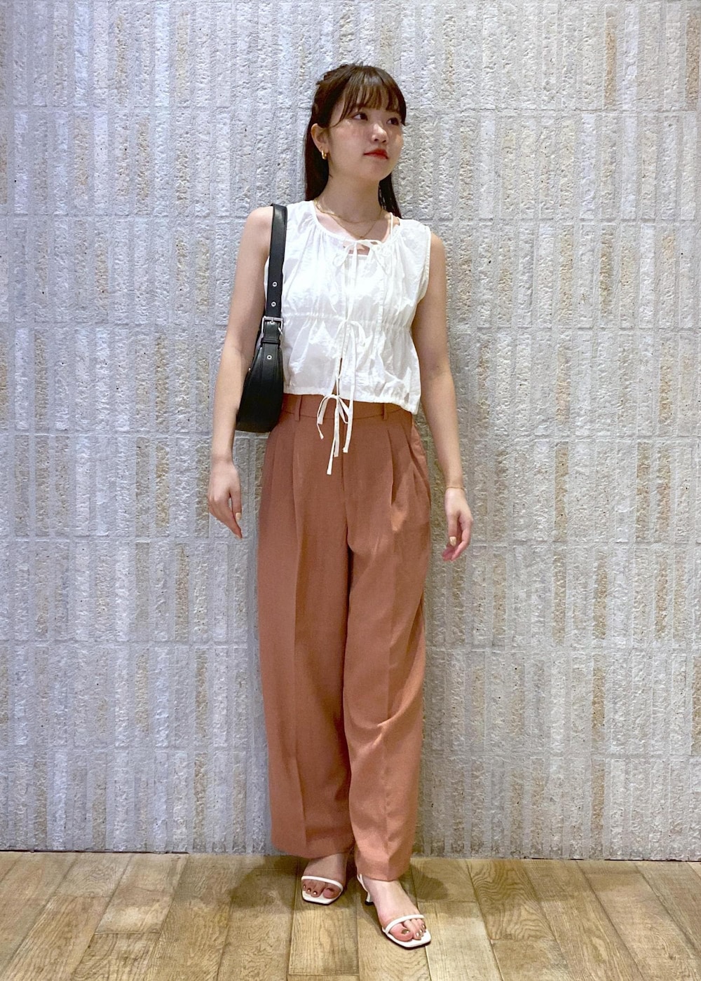 ホワイト系のサンダル、ホワイト系のキャミソール、ブラック系のショルダーバッグを着用したレディースの夏コーディネートの2枚目の写真