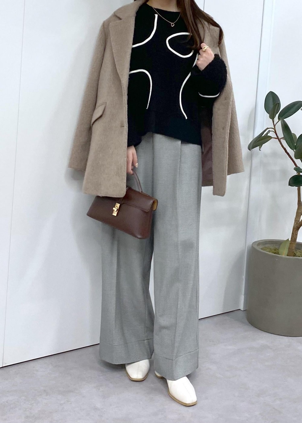 ホワイト系のブーツ、ブラック系のニット/セーター、ブラウン系のその他アウターを着用したレディースの秋コーディネートの4枚目の写真