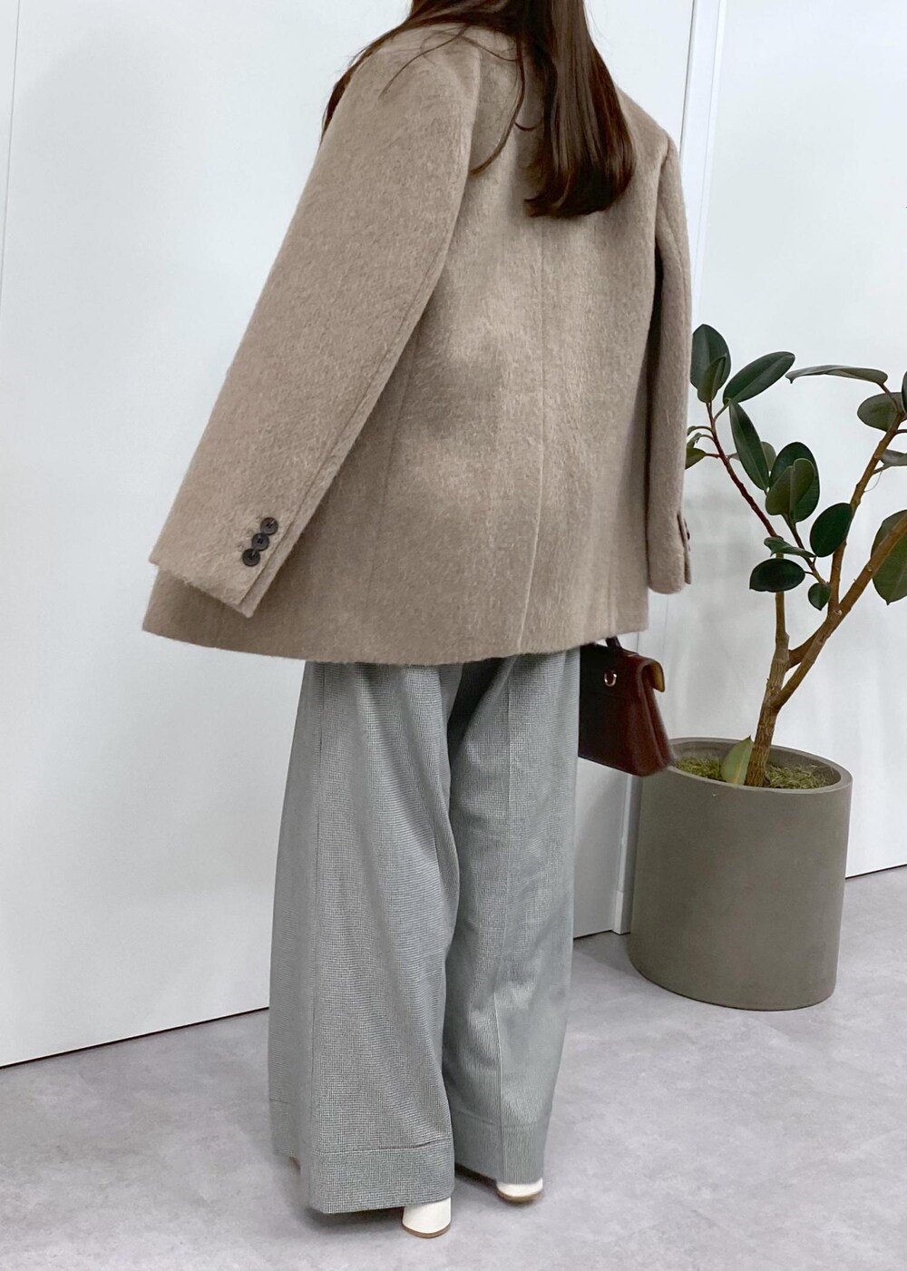 ホワイト系のブーツ、ブラック系のニット/セーター、ブラウン系のその他アウターを着用したレディースの秋コーディネートの7枚目の写真