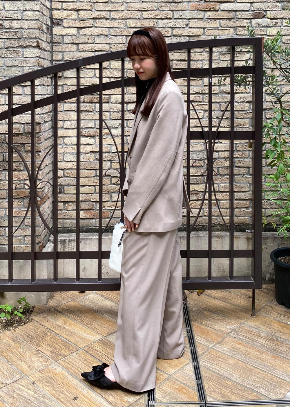 ブラック系のサンダル、ホワイト系のショルダーバッグ、ブラック系のニット/セーターを着用したレディースの秋コーディネートの3枚目の写真