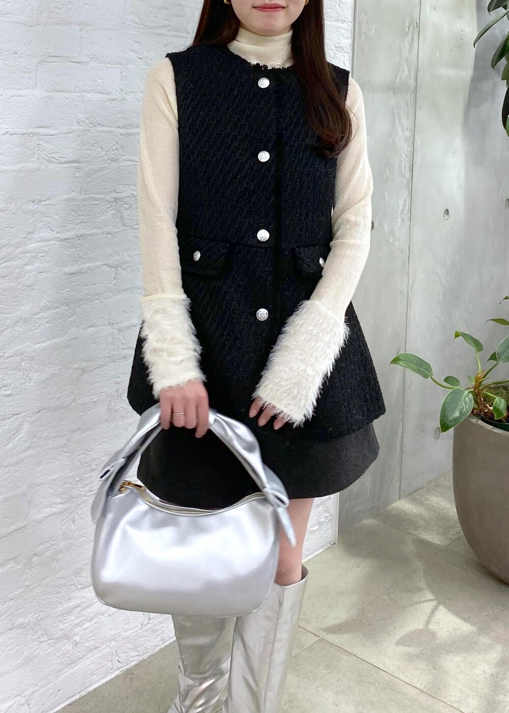 グレー系のその他パンツ、シルバー系のブーツ、ホワイト系のニット/セーターを着用したレディースの冬コーディネートの3枚目の写真