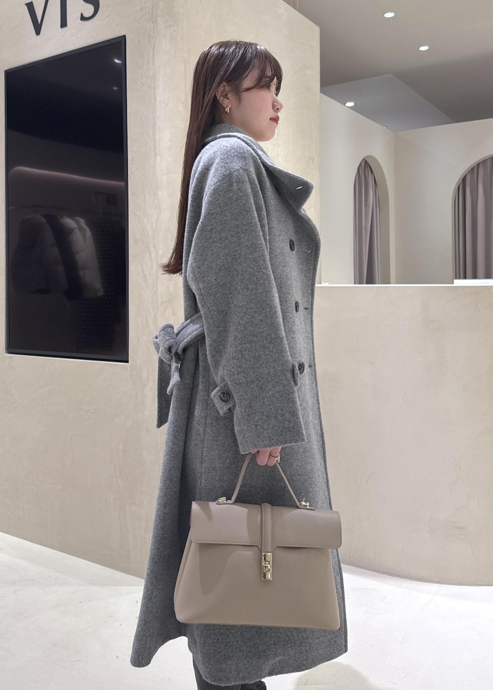 ベージュ系のハンドバッグ、ホワイト系のニット/セーター、グレー系のその他アウターを着用したレディースの秋コーディネートの6枚目の写真