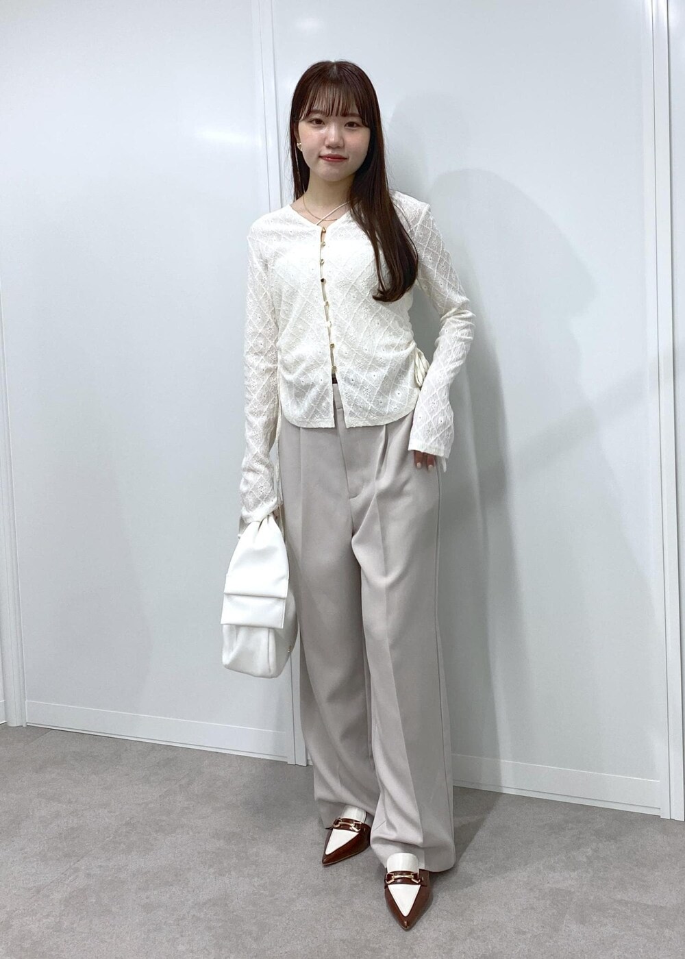 ブラウン系のパンプス、ホワイト系のキャミソール、ホワイト系のカーディガン/ボレロを着用したレディースの冬コーディネートの2枚目の写真