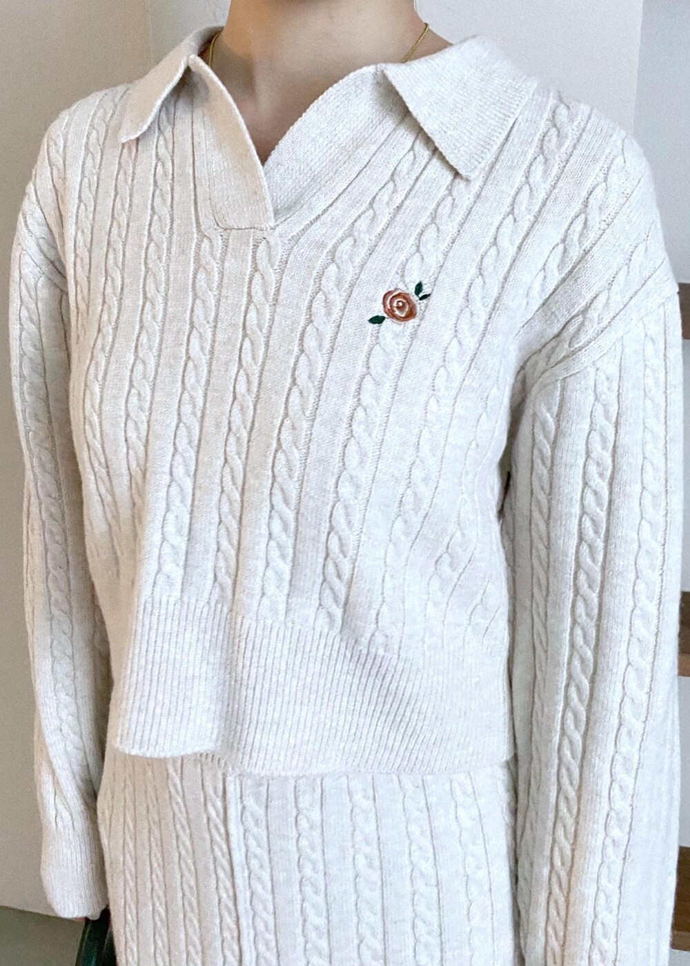 グリーン系のショルダーバッグ、ベージュ系のブーツ、ベージュ系のスカートを着用したレディースの冬コーディネートの3枚目の写真