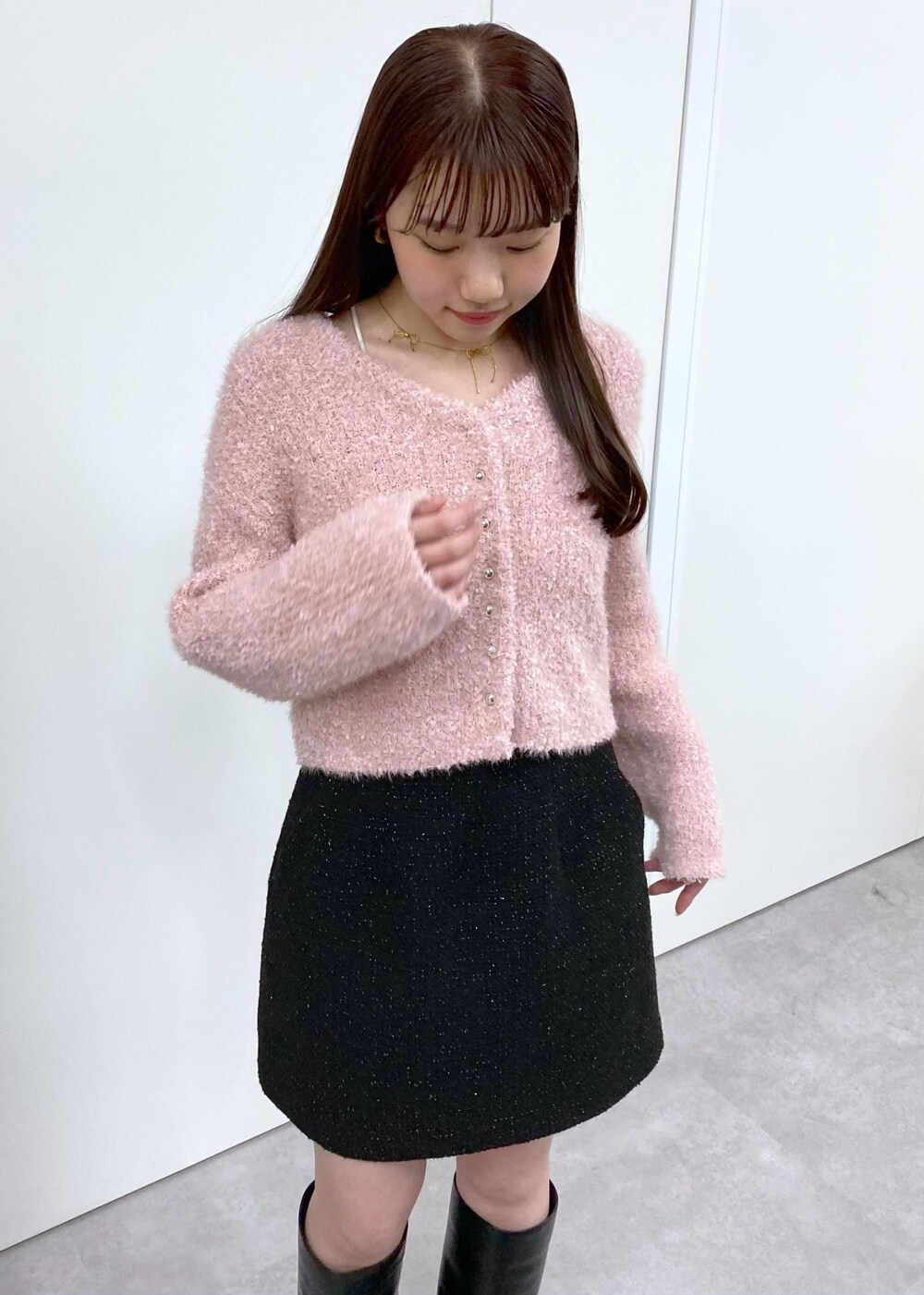 ホワイト系のキャミソール、ブラック系のブーツ、ブラック系のスカートを着用したレディースの冬コーディネートの4枚目の写真