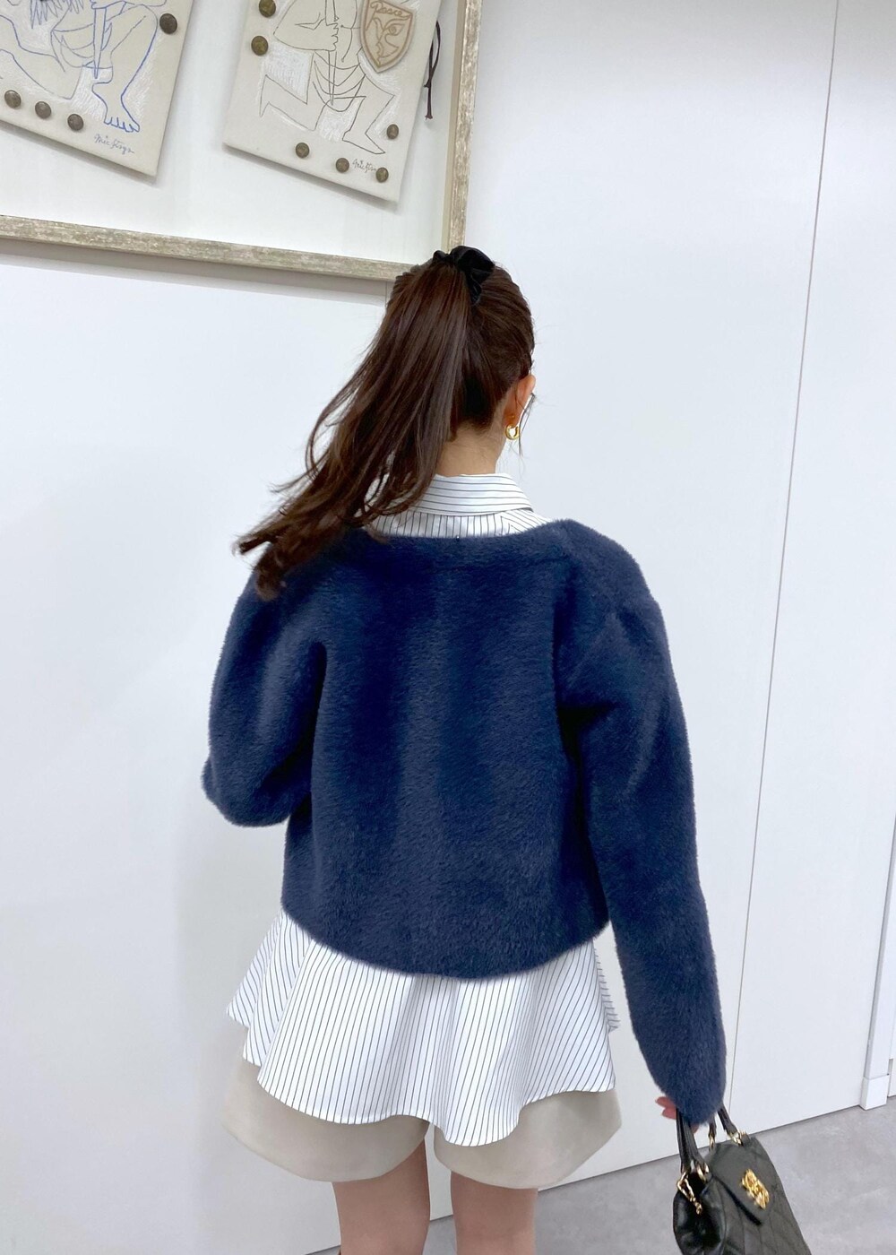 ベージュ系のブーツ、ブルー系のカーディガン/ボレロ、ベージュ系のその他パンツを着用したレディースの冬コーディネートの5枚目の写真