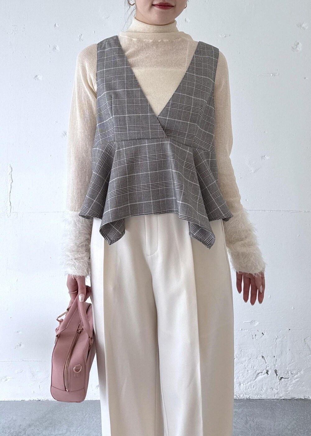 ホワイト系のスラックス、ピンク系のボストンバッグ、ベージュ系のブーツを着用したレディースの秋コーディネートの3枚目の写真