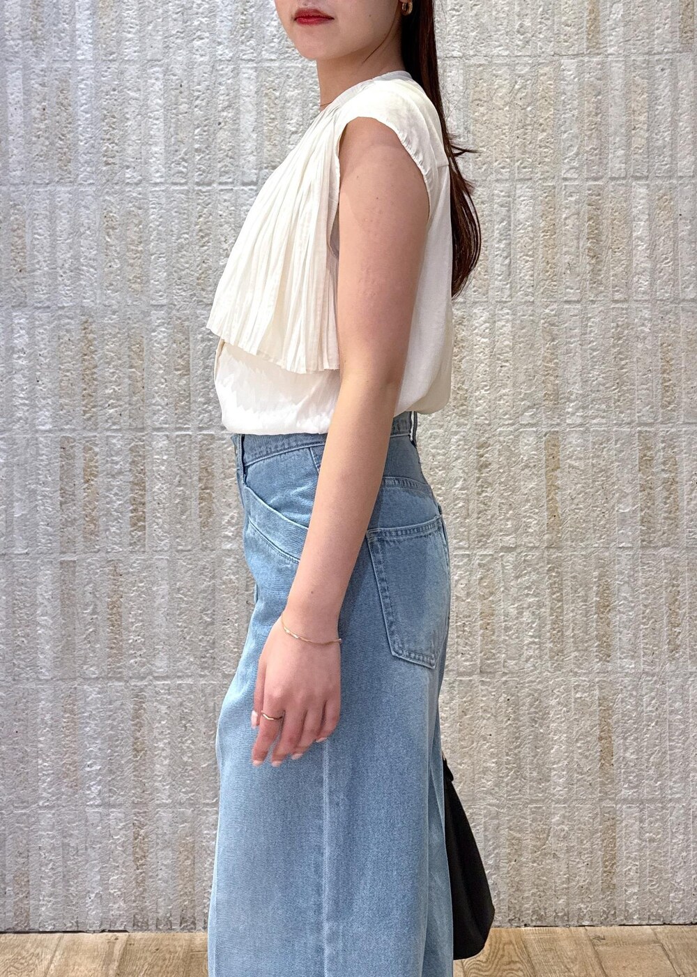 ブラック系のショルダーバッグ、ブラック系のサンダル、ホワイト系のキャミソールを着用したレディースの夏コーディネートの6枚目の写真