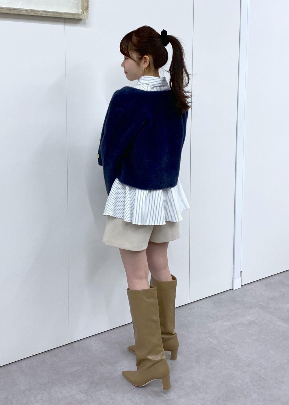 ベージュ系のブーツ、ブルー系のカーディガン/ボレロ、ベージュ系のその他パンツを着用したレディースの冬コーディネートの6枚目の写真