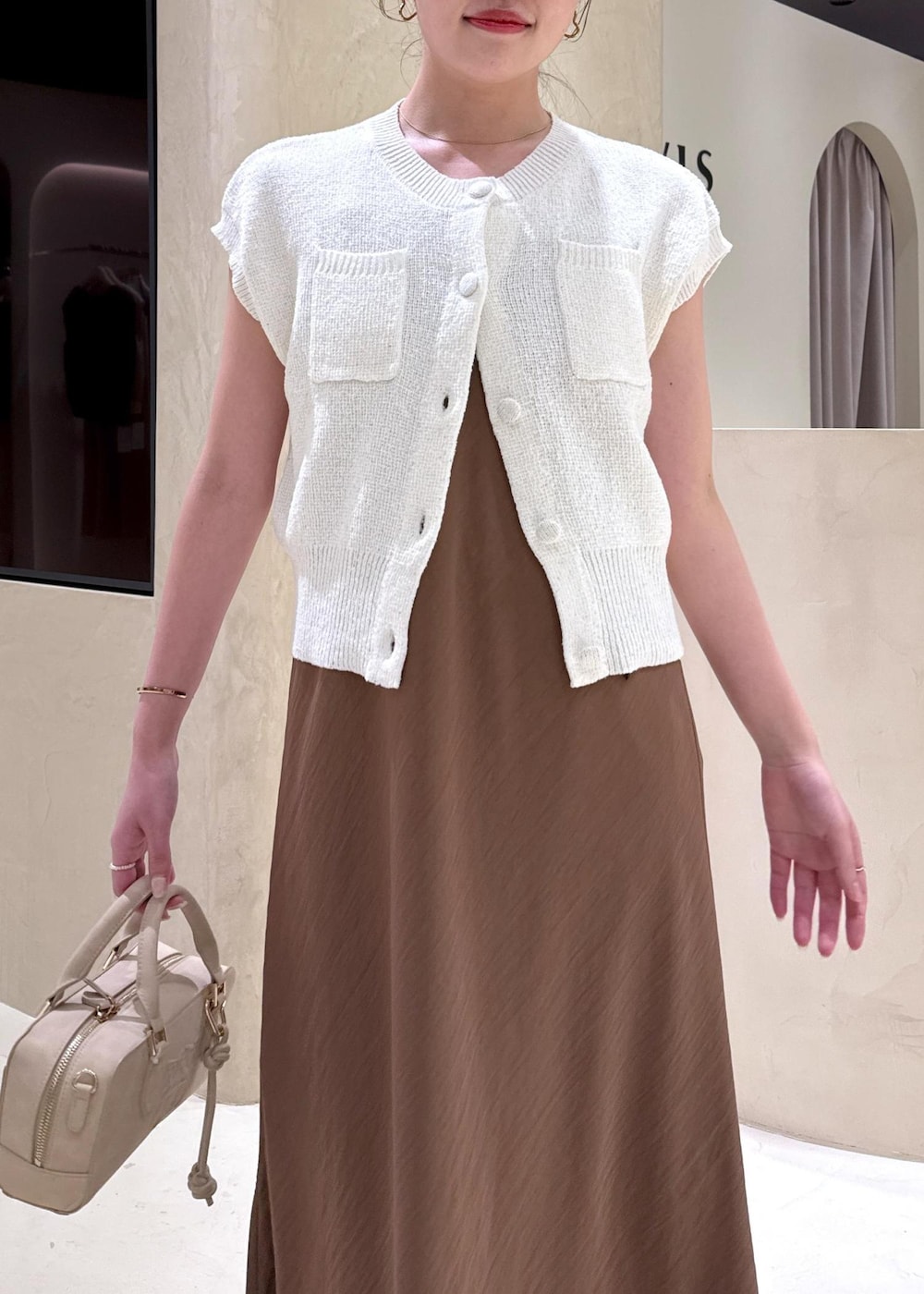 ホワイト系のキャミソール、ブラウン系のワンピース、ホワイト系のカーディガン/ボレロを着用したレディースの夏コーディネートの3枚目の写真