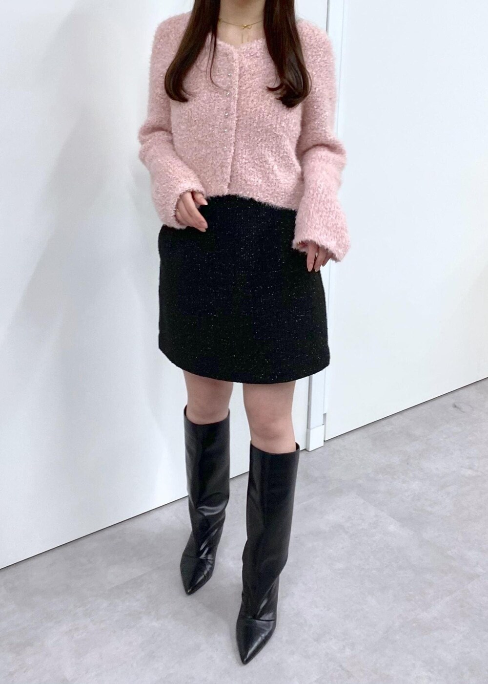 ホワイト系のキャミソール、ブラック系のブーツ、ブラック系のスカートを着用したレディースの冬コーディネートの8枚目の写真