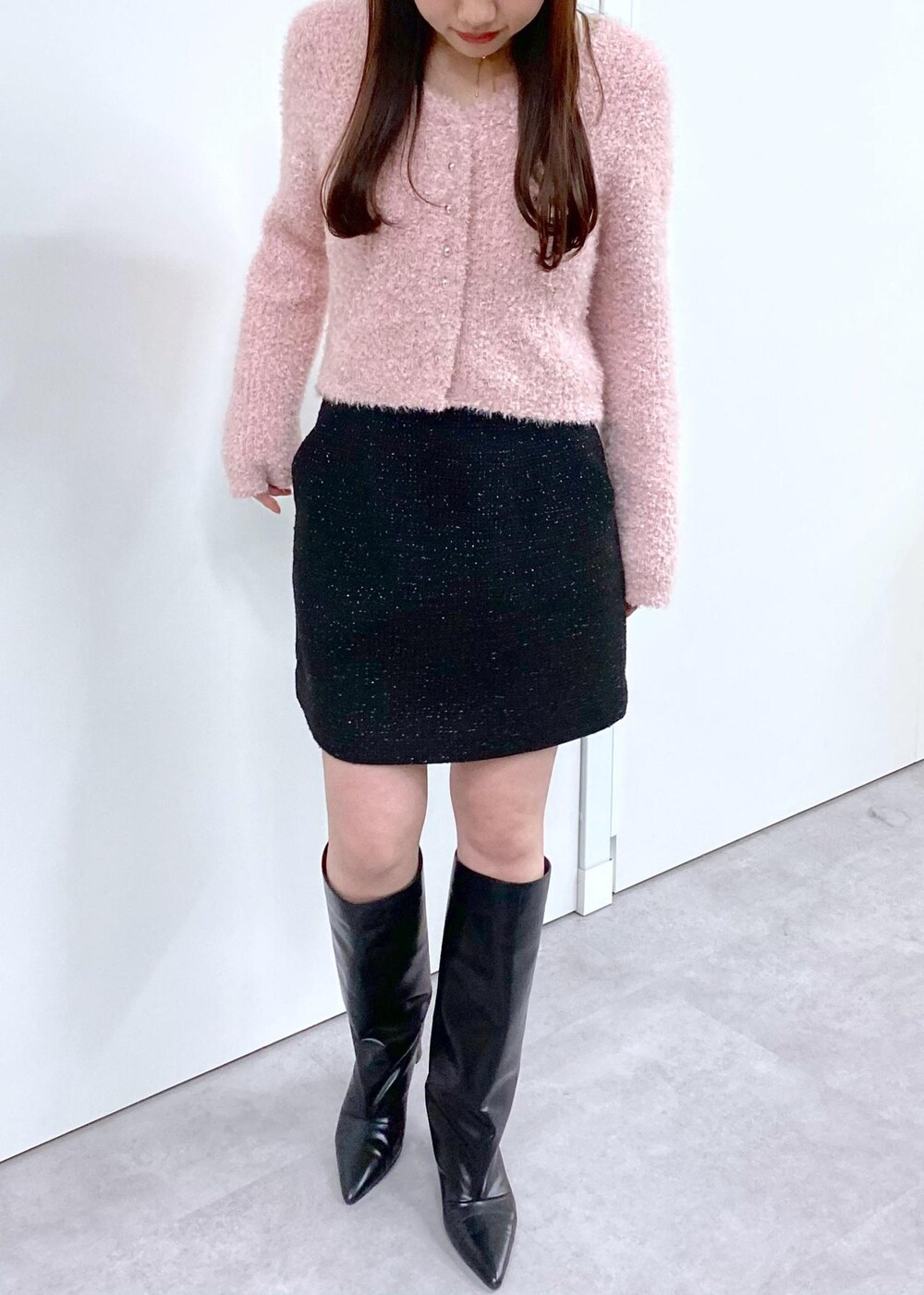 ホワイト系のキャミソール、ブラック系のブーツ、ブラック系のスカートを着用したレディースの冬コーディネートの3枚目の写真