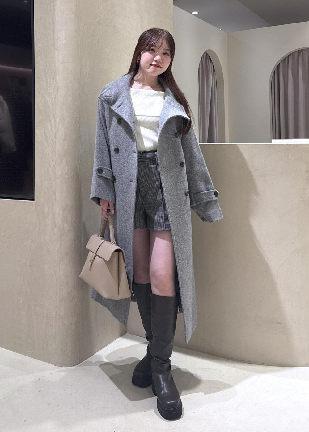 ベージュ系のハンドバッグ、ホワイト系のニット/セーター、グレー系のその他アウターを着用したレディースの秋コーディネートの2枚目の写真