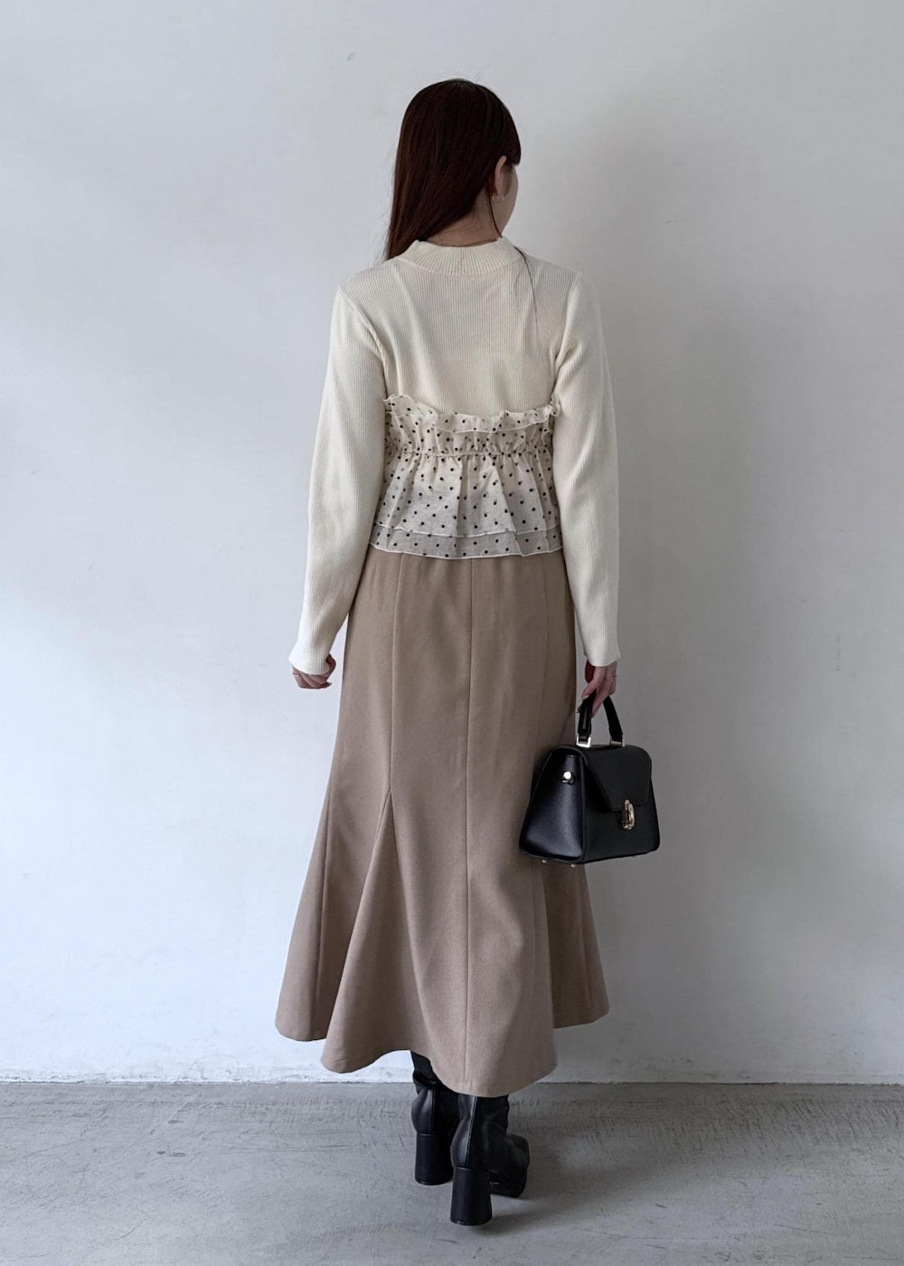 ホワイト系のキャミソール、ベージュ系のスカート、ブラック系のブーツを着用したレディースの秋コーディネートの6枚目の写真