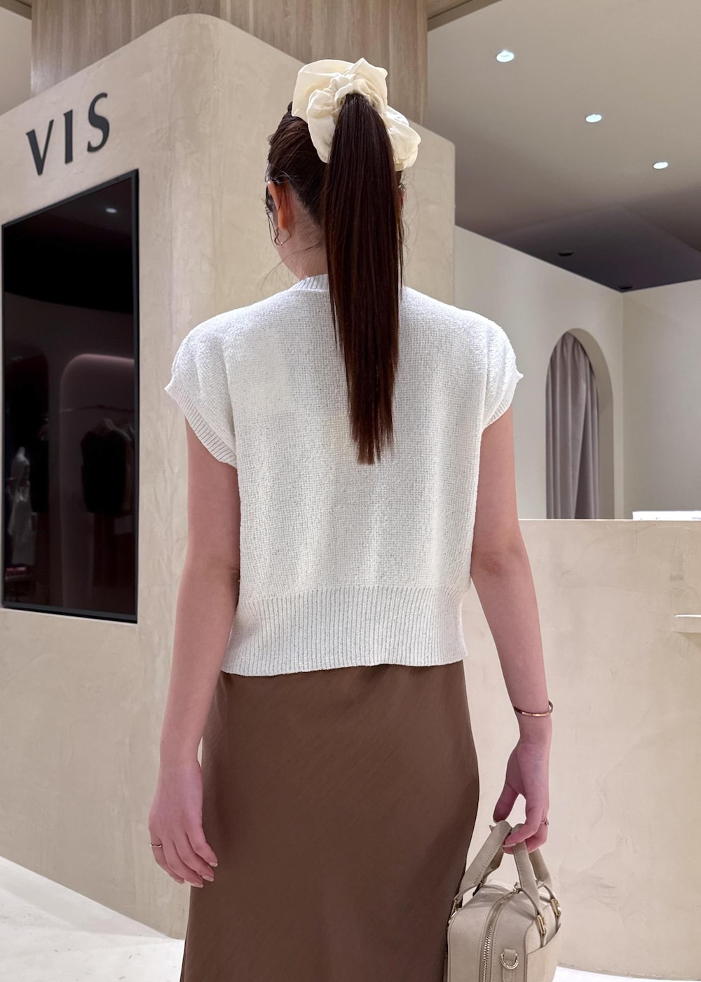 ホワイト系のキャミソール、ブラウン系のワンピース、ホワイト系のカーディガン/ボレロを着用したレディースの夏コーディネートの6枚目の写真