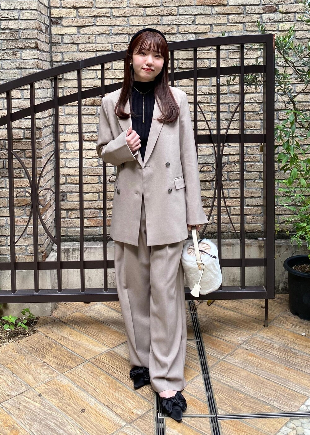 ブラック系のサンダル、ホワイト系のショルダーバッグ、ブラック系のニット/セーターを着用したレディースの秋コーディネートの2枚目の写真