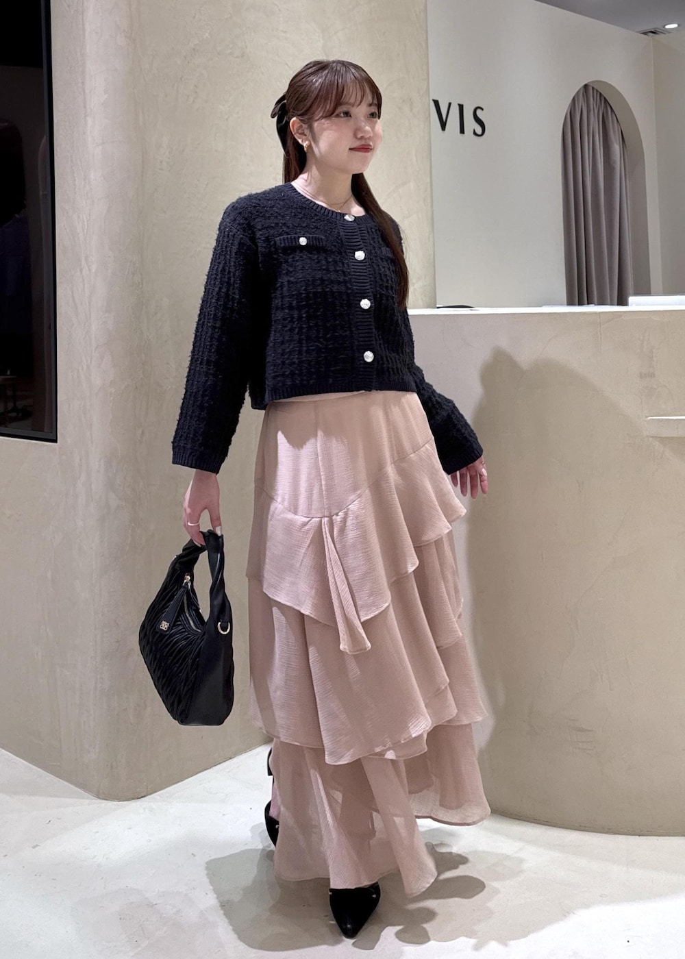 ホワイト系のキャミソール、ブラック系のパンプス、ブラック系のハンドバッグを着用したレディースの秋コーディネートの2枚目の写真