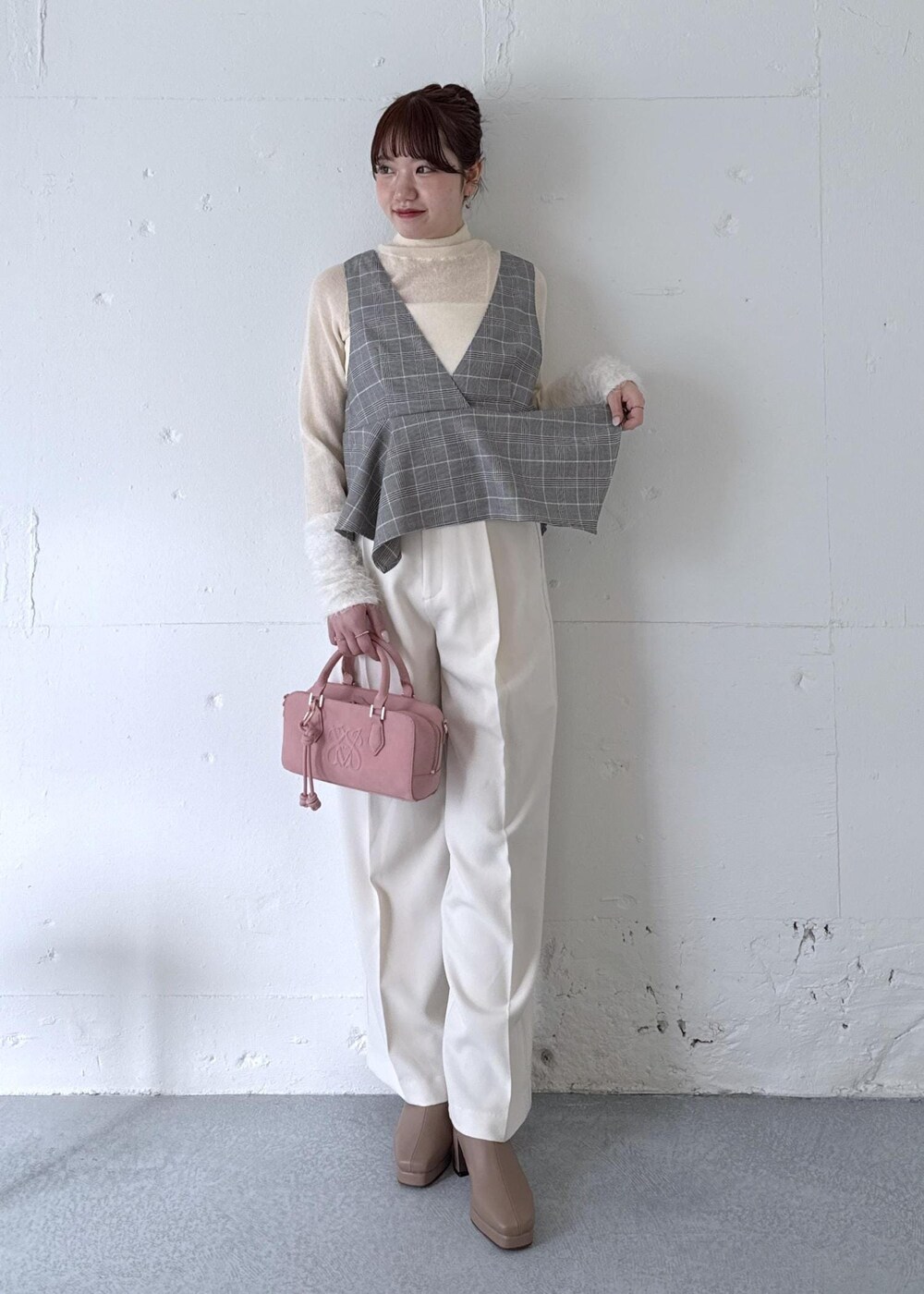 ホワイト系のスラックス、ピンク系のボストンバッグ、ベージュ系のブーツを着用したレディースの秋コーディネートの2枚目の写真