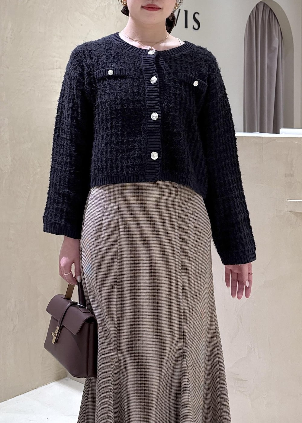 ブラウン系のショルダーバッグ、イエロー系のパンプス、ベージュ系のスカートを着用したレディースの秋コーディネートの3枚目の写真