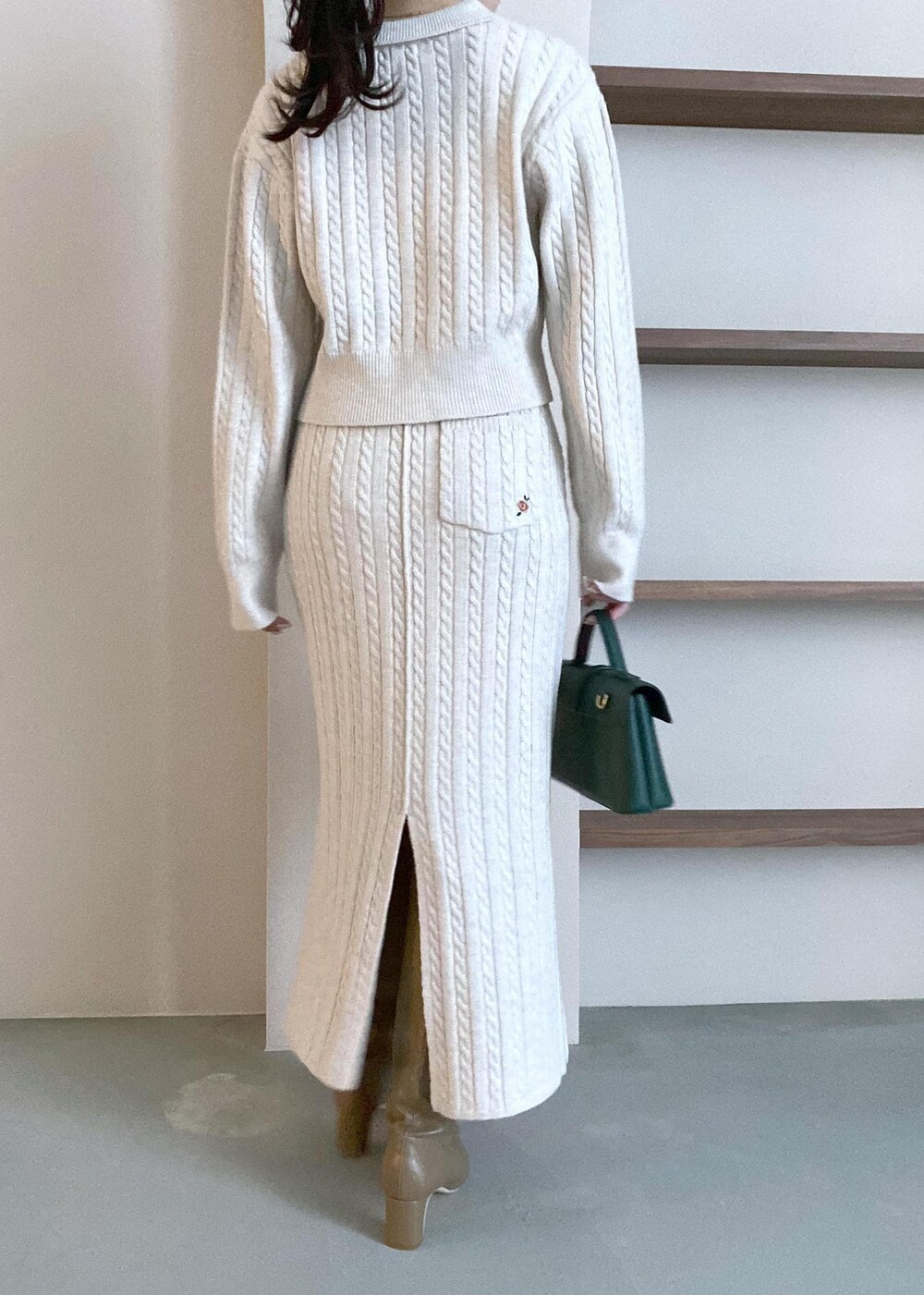 グリーン系のショルダーバッグ、ベージュ系のブーツ、ベージュ系のスカートを着用したレディースの冬コーディネートの8枚目の写真