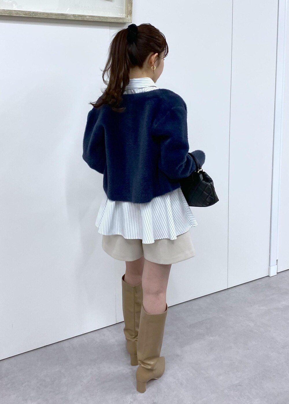 ベージュ系のブーツ、ブルー系のカーディガン/ボレロ、ベージュ系のその他パンツを着用したレディースの冬コーディネートの7枚目の写真