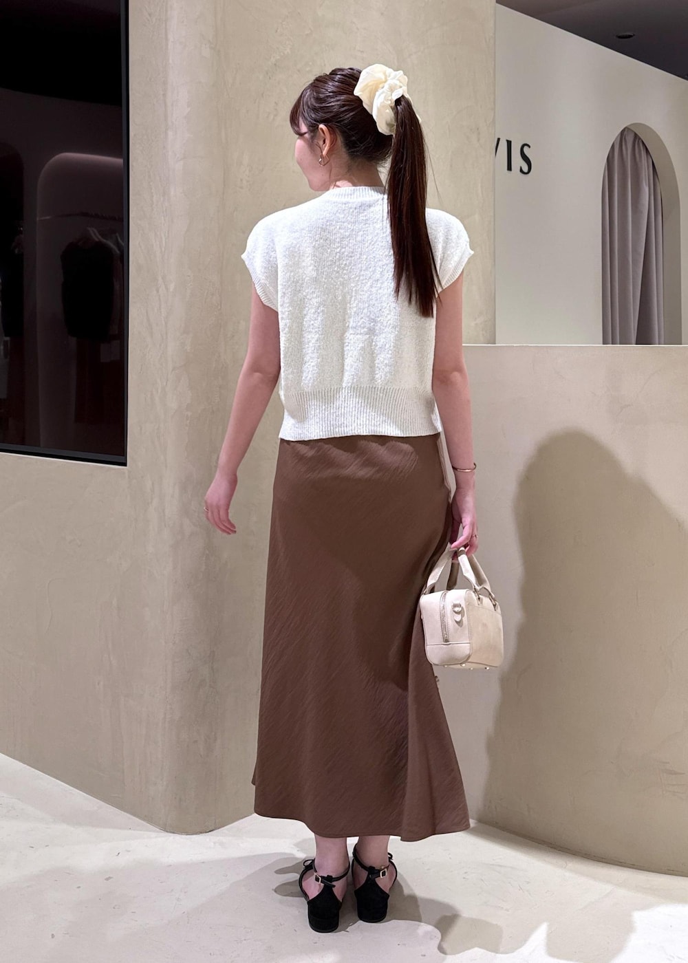 ホワイト系のキャミソール、ブラウン系のワンピース、ホワイト系のカーディガン/ボレロを着用したレディースの夏コーディネートの7枚目の写真