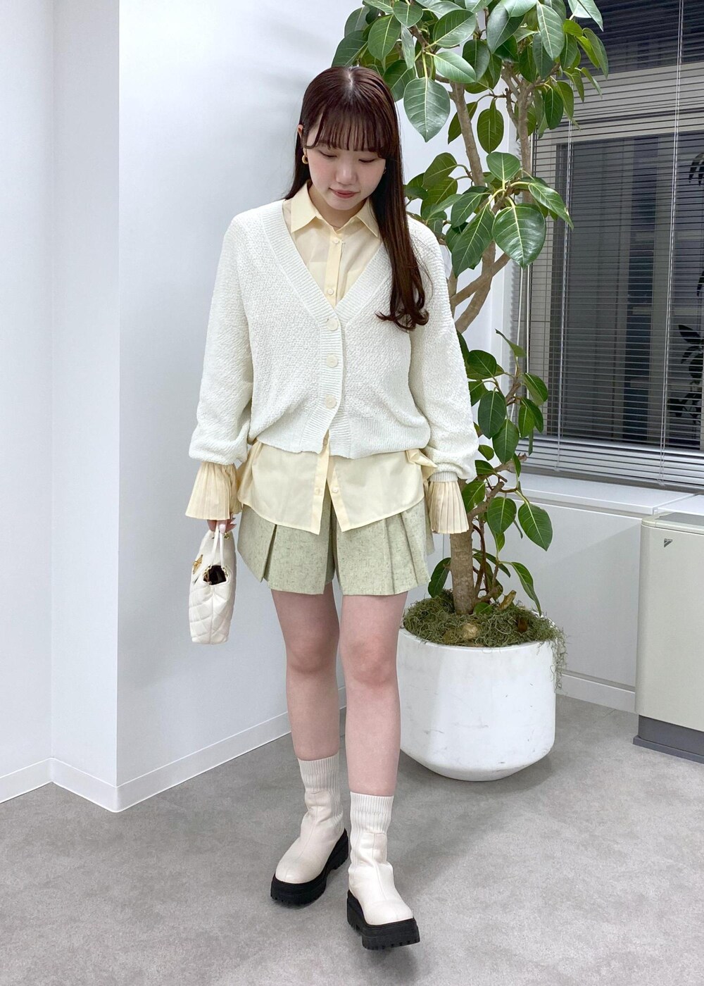 ホワイト系のブーツ、ホワイト系のカーディガン/ボレロ、ホワイト系のその他パンツを着用したレディースの冬コーディネートの2枚目の写真