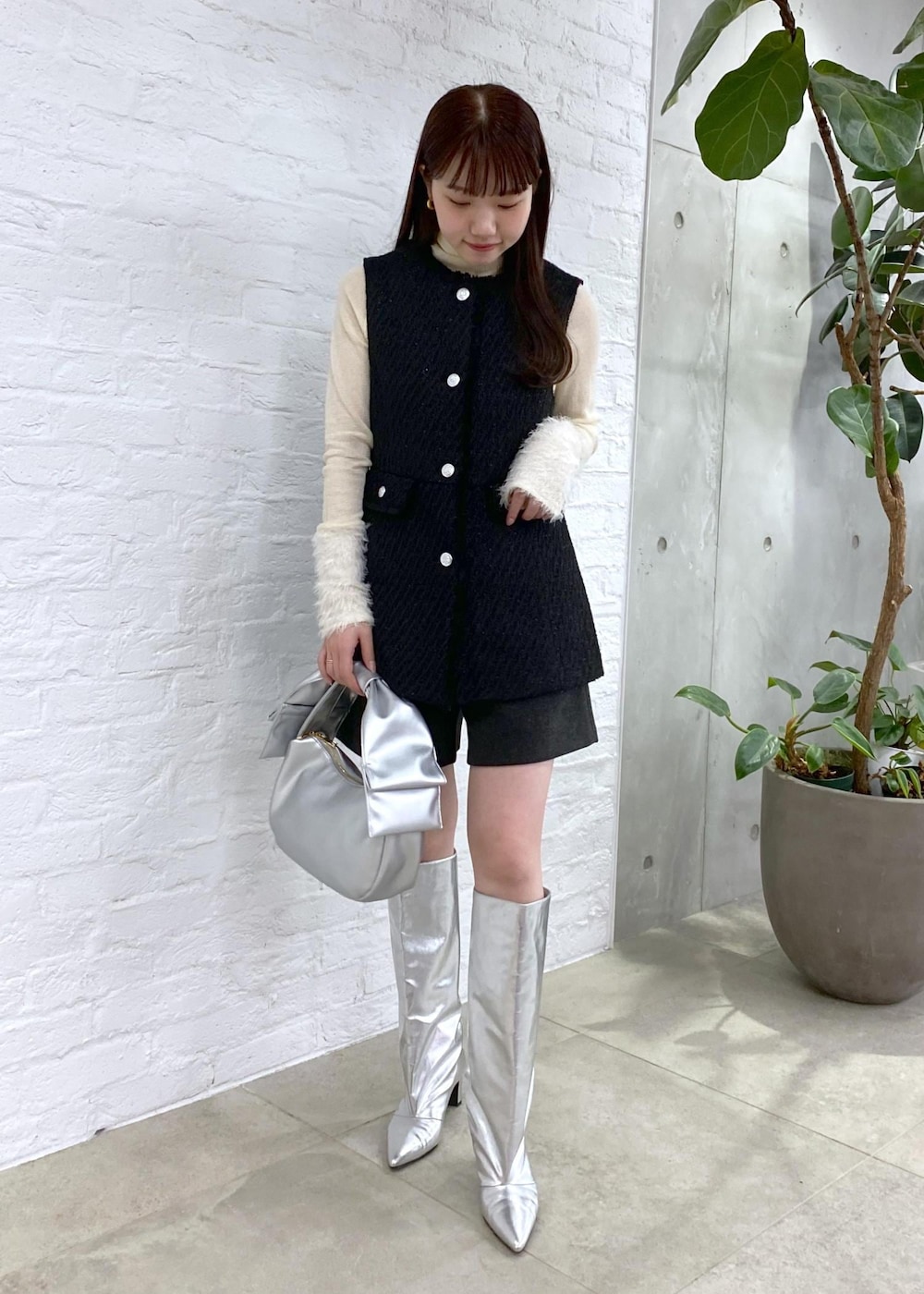 グレー系のその他パンツ、シルバー系のブーツ、ホワイト系のニット/セーターを着用したレディースの冬コーディネートの2枚目の写真