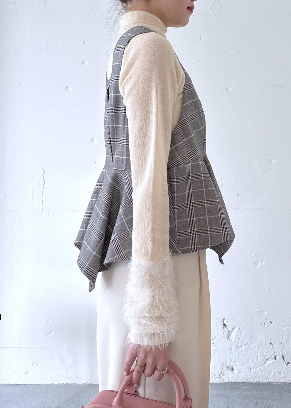 ホワイト系のスラックス、ピンク系のボストンバッグ、ベージュ系のブーツを着用したレディースの秋コーディネートの4枚目の写真