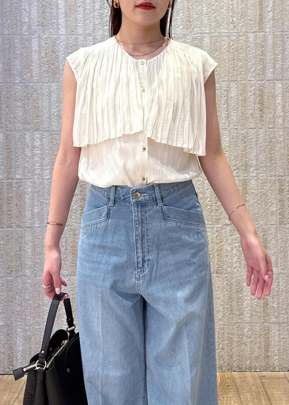 ブラック系のショルダーバッグ、ブラック系のサンダル、ホワイト系のキャミソールを着用したレディースの夏コーディネートの4枚目の写真