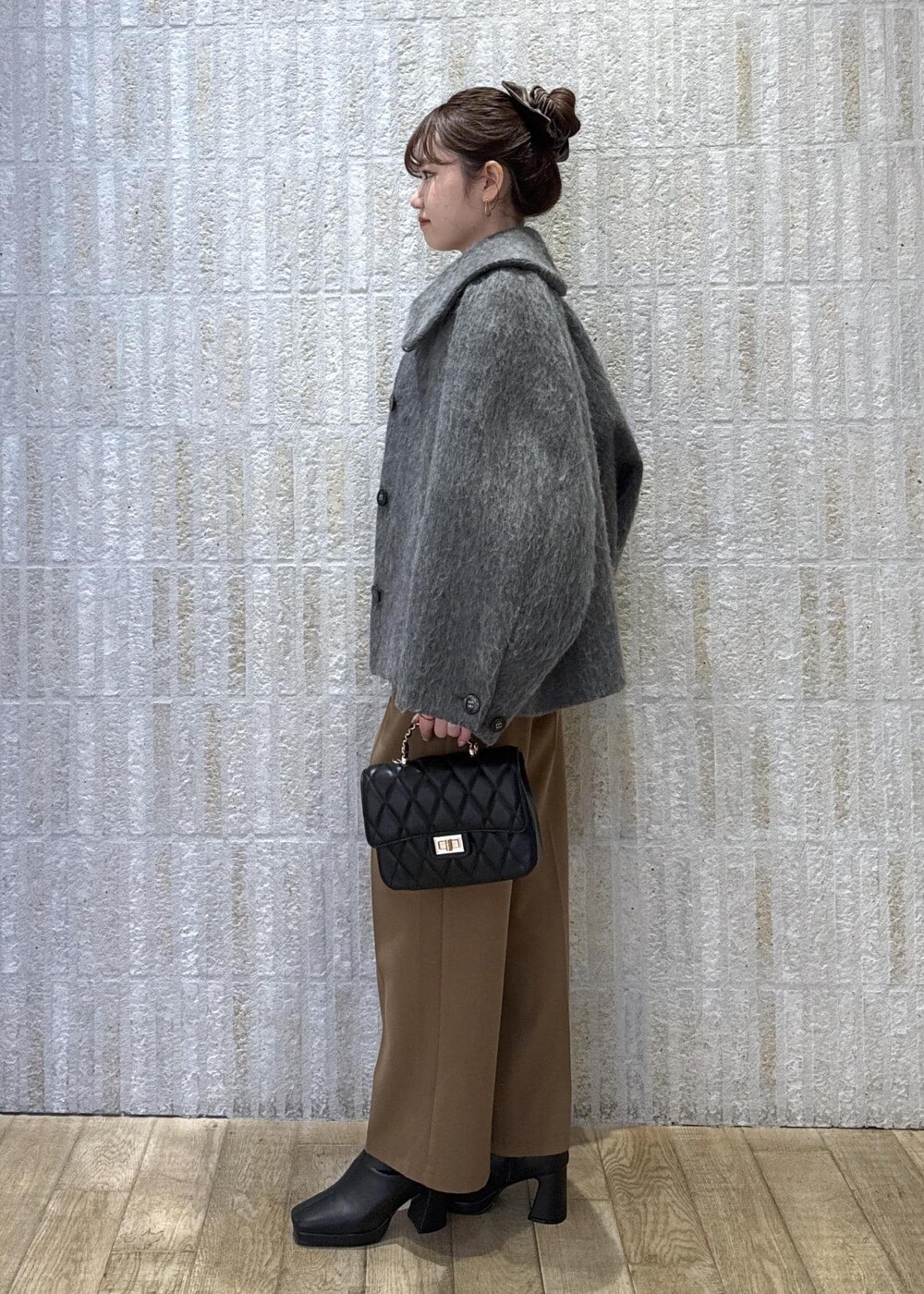 グレー系のブルゾン、ホワイト系のニット/セーター、イエロー系のその他パンツを着用したレディースの冬コーディネートの7枚目の写真