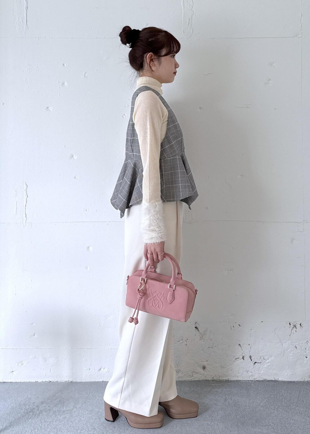 ホワイト系のスラックス、ピンク系のボストンバッグ、ベージュ系のブーツを着用したレディースの秋コーディネートの5枚目の写真