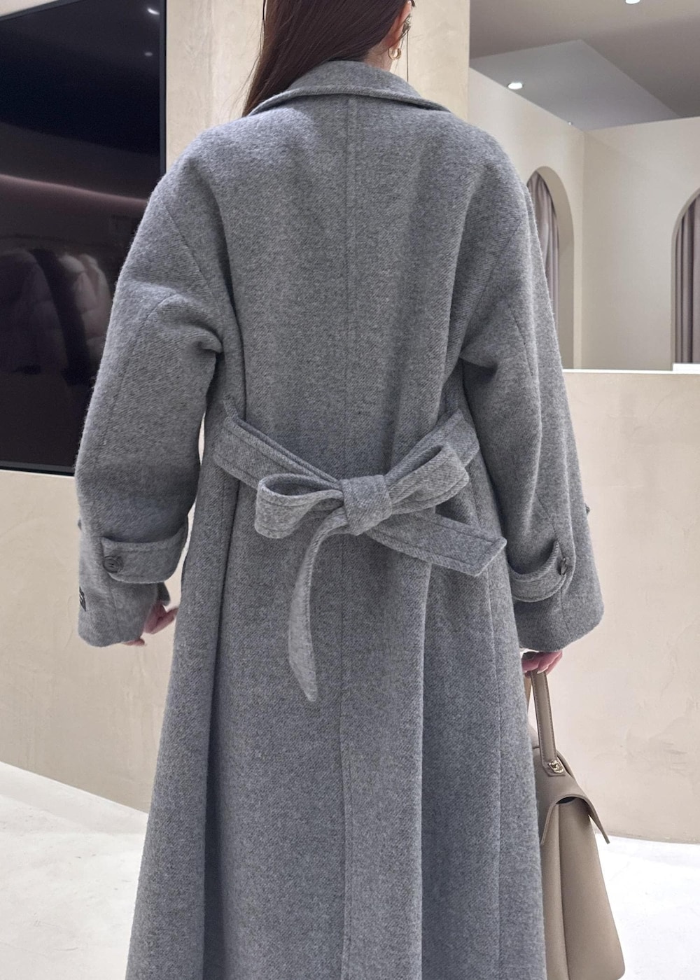 ベージュ系のハンドバッグ、ホワイト系のニット/セーター、グレー系のその他アウターを着用したレディースの秋コーディネートの8枚目の写真