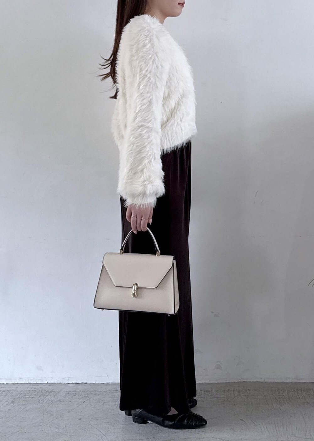 ホワイト系のキャミソール、ブラック系のパンプス、ブラック系のスカートを着用したレディースの秋コーディネートの5枚目の写真