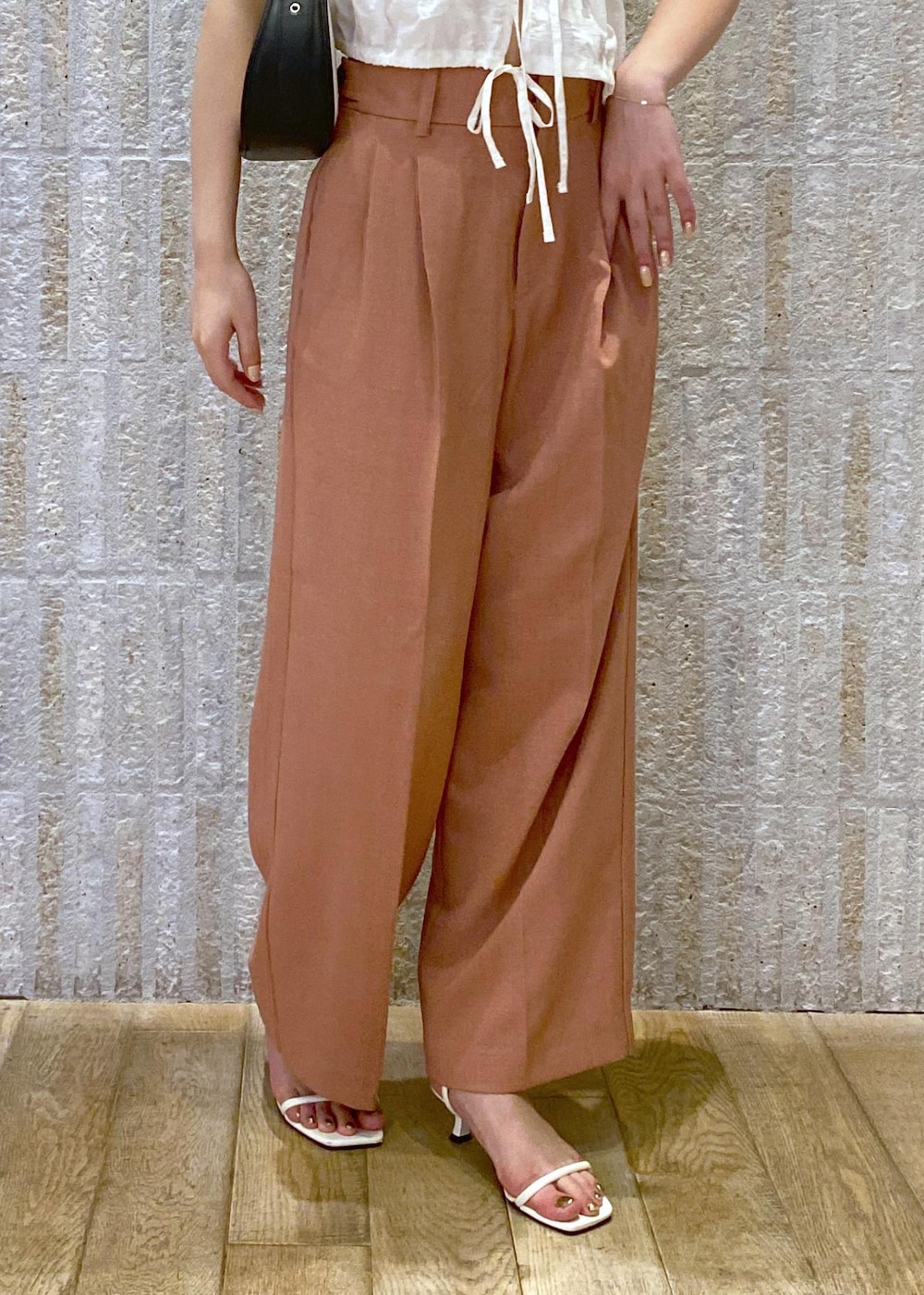 ホワイト系のサンダル、ホワイト系のキャミソール、ブラック系のショルダーバッグを着用したレディースの夏コーディネートの3枚目の写真